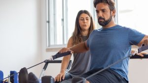 A Man In Blue Shirt Exercising with Supervision