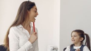 Cheerful woman and kid having fun in office