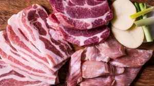 Close-Up Shot of Slices of Raw Meat on a Wooden Chopping Board