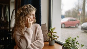 Woman Talking Through the Phone and Looking out the Window