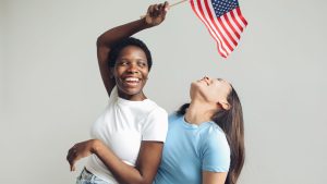 Woman in White Crew Neck T-shirt Holding USA Flag