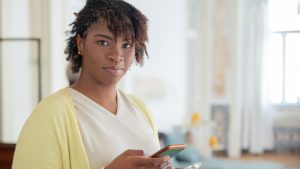 Woman in Yellow Cardigan Holding Smartphone