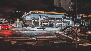 Busy urban street with traffic on and gas station near